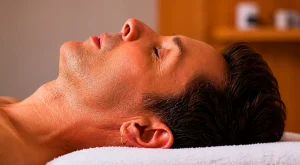 Hombre recostado con los ojos cerrados durante un ritual facial en Organic Spa